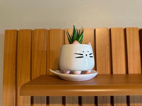 a vase sitting on a table with a plant in it at Flat para 6 pessoas no Home Green Home in Campos do Jordão