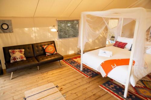 a bedroom with a bed and a couch in a room at Haida Gwaii Glamping in Tlell