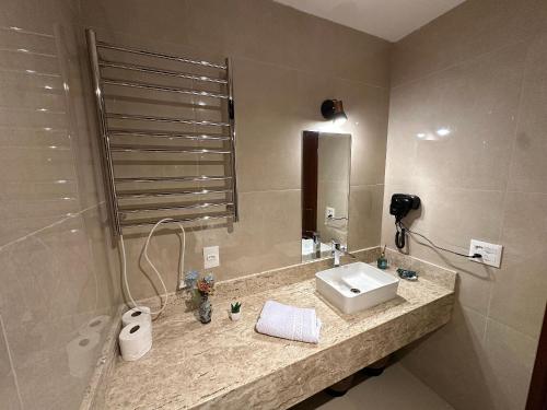 a bathroom with a sink and a mirror at Flat para 6 pessoas no Home Green Home in Campos do Jordão