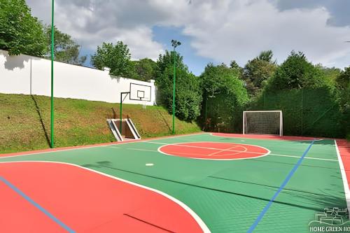 an outdoor basketball court with a basketball hoop at Flat para 6 pessoas no Home Green Home in Campos do Jordão