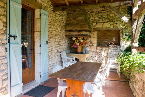 une table et des chaises en bois sur une terrasse dans l'établissement chez moutier, à Thénac