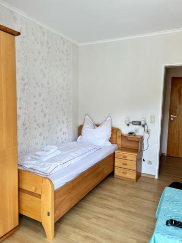a bedroom with a wooden bed and a wooden dresser at Hotel Haus Christa in Bad Bertrich