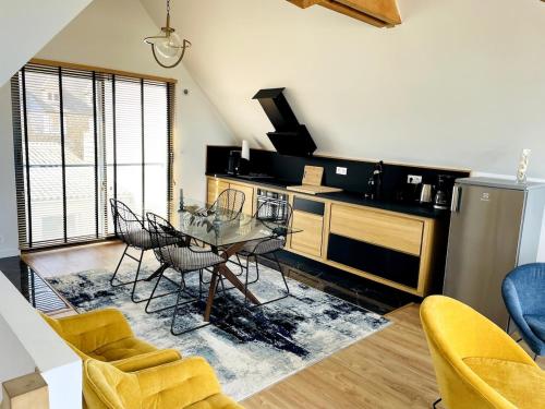 une cuisine avec une table en verre et des chaises dans une pièce dans l'établissement L'Atelier de Mer, à Perros-Guirec