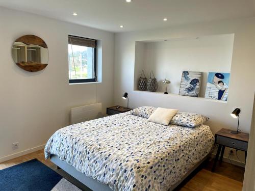une chambre avec un lit et un miroir au mur dans l'établissement L'Atelier de Mer, à Perros-Guirec