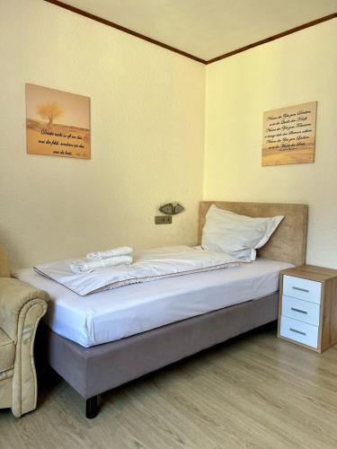 a bedroom with a bed and a nightstand and a bed sidx sidx at Hotel Haus Christa in Bad Bertrich