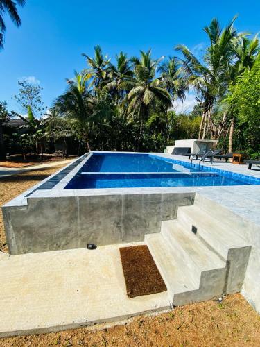 a swimming pool with stairs in front of a house at The Sigiri Roar in Sigiriya