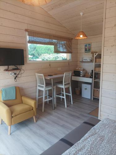une pièce avec une table, des chaises et une télévision dans l'établissement Les Bambous, à Montalivet-les-Bains