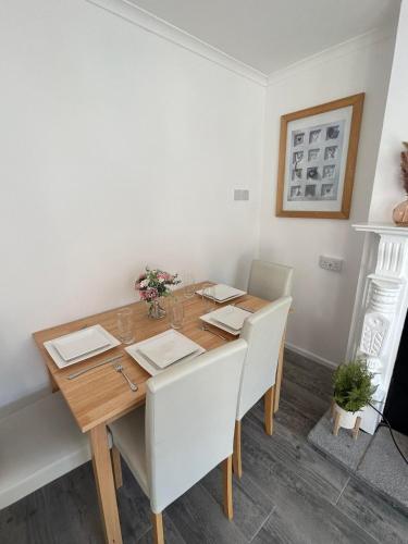 a dining room with a wooden table and white chairs at Central Apartment Newry City in Newry