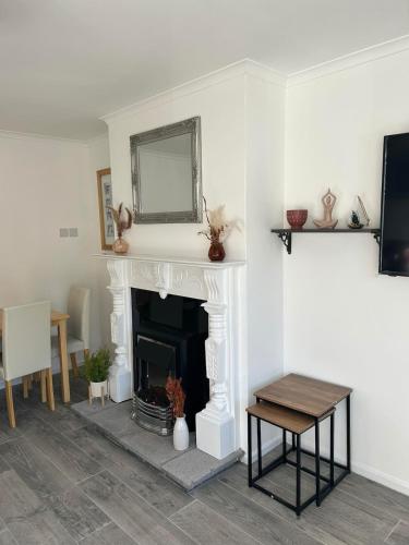 a living room with a fireplace with a mirror and a table at Central Apartment Newry City in Newry
