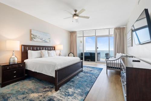 a bedroom with a bed and a desk and a window at Turquoise D1306 in Orange Beach