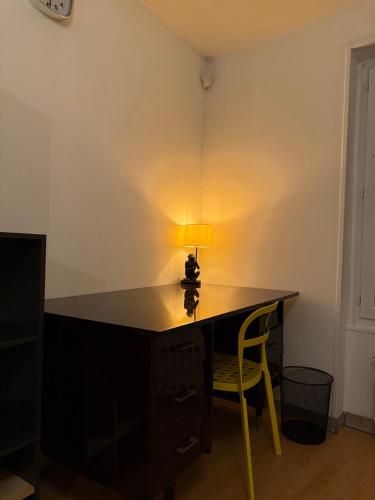 a desk with a lamp and a chair in a room at Le Repaire des Grands Moments in Vierzon