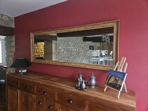 a mirror on top of a dresser in a room at Le temps suspendu in Sedan