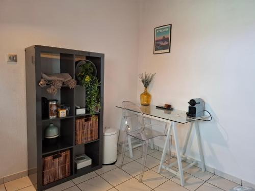 une chambre avec une table, une table et une étagère dans l'établissement Chambre cosy et salle d'eau dans maison Mérignac Arlac, à Mérignac