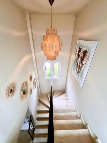 a staircase in a house with a chandelier at Exclusive house in Finestrat in Cala de Finestrat