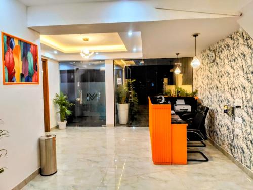una hall con un bancone arancione al centro di Hotel Mavens House Artemis Hospital Road a Gurgaon