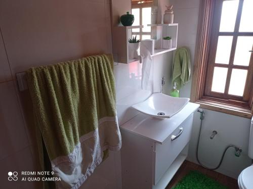 ein Badezimmer mit Waschbecken und Duschvorhang in der Unterkunft Chalé Boas Novas Piranguçu MG in Piranguçu