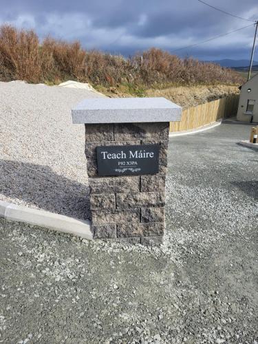 a sign on a stone pillar in the middle of a road at Teach Máire, Downings in Downings