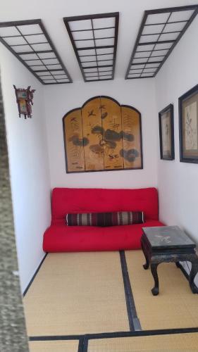 a red couch in a room with a table at Gästehaus Fuchsröhre in Welcherath