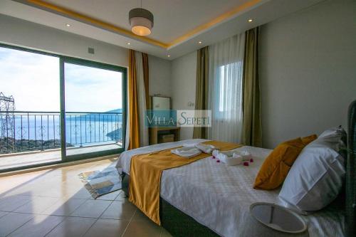 a bedroom with a bed and a large window at Glennhouse in Kaş