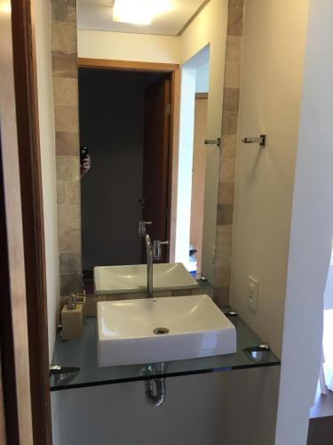 a bathroom with a sink and a mirror at Praia dos Carneiros, Flat com Vista Mar, 2 quartos, em Resort de Luxo in Tamandaré