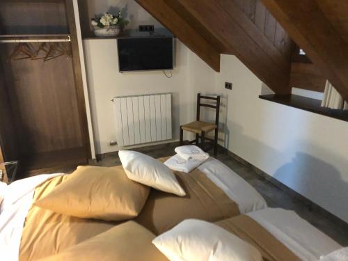 a bedroom with a bed with pillows and a tv at Casa FOR in Labuerda