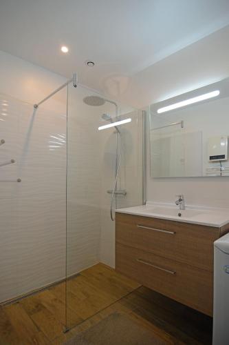 une salle de bain avec une douche en verre et un lavabo dans l'établissement Maison sur la dune à 100m de la plage, à La Guérinière