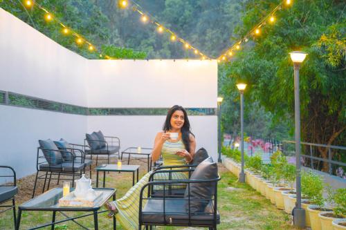 a woman standing in a patio with lights and tables at Perfectstayz The Jungle Resort, Shivpuri in Shivpuri