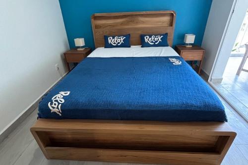 Un dormitorio con una cama con un edredón azul. en L'écrin du Rivage, en Sainte-Anne