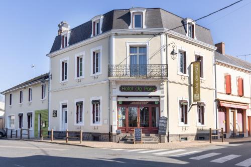 a white building on the corner of a street at Hotel De Paris Jaligny in Jaligny