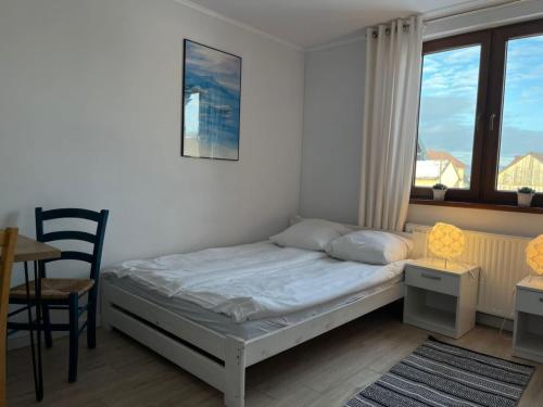 a small bedroom with a bed and a table and chairs at Apartamenty u Majki 2 in Frydman