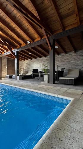 an outdoor swimming pool with a pavilion and a patio at Ballester's Dream in San Martín de los Andes