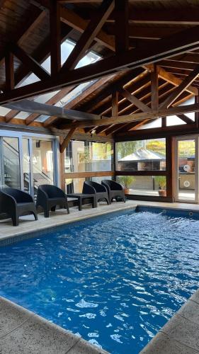 a large swimming pool with chairs and a building at Ballester's Dream in San Martín de los Andes
