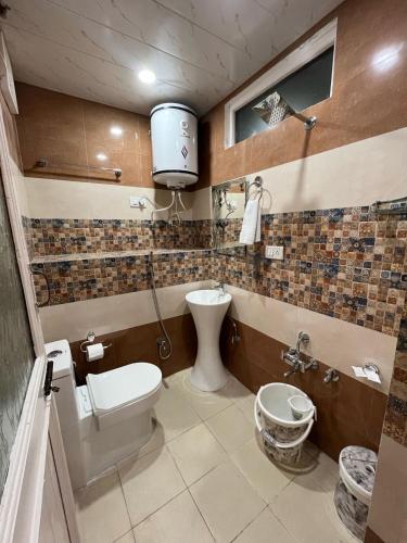 a bathroom with a toilet and a sink at Hezzah Cottage in Srinagar