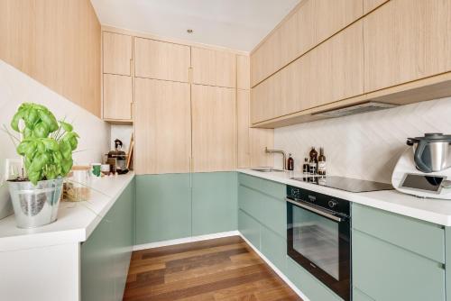 une cuisine avec des armoires en bois et un four à plaques de cuisson dans l'établissement MARAIS - Rue au maire - Chinatown, à Paris