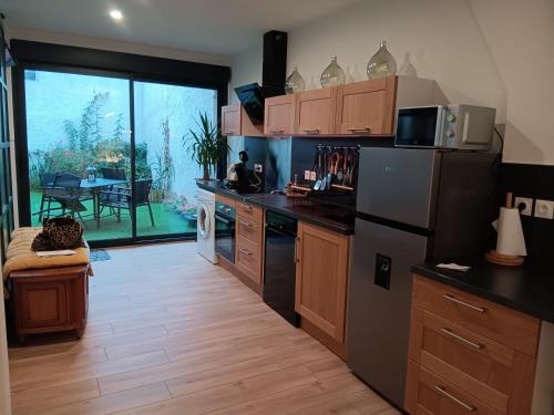 Il comprend une cuisine équipée d'un réfrigérateur et d'une table avec une terrasse. dans l'établissement Petit cocon au coeur de Vichy, à Vichy