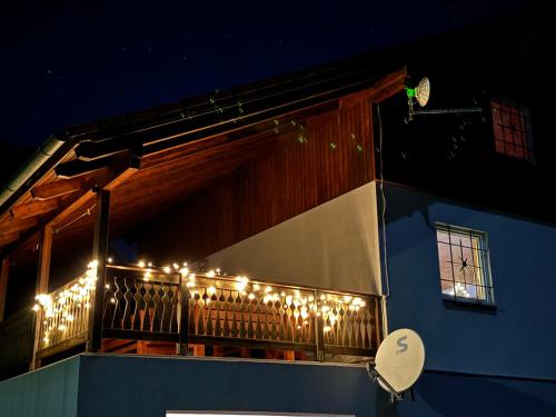 a balcony with christmas lights on a blue building at Ginkgo House in Kehidakustány