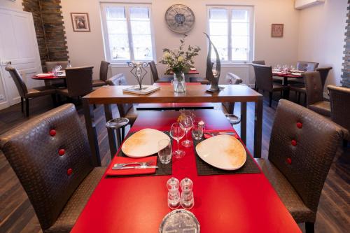 a dining room with a red table and chairs at Hotel De Paris Jaligny in Jaligny