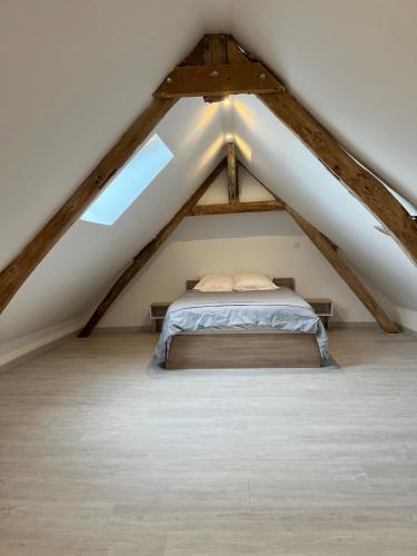une chambre avec un lit dans un grenier dans l'établissement La sérénité en baie de somme, à Béhen