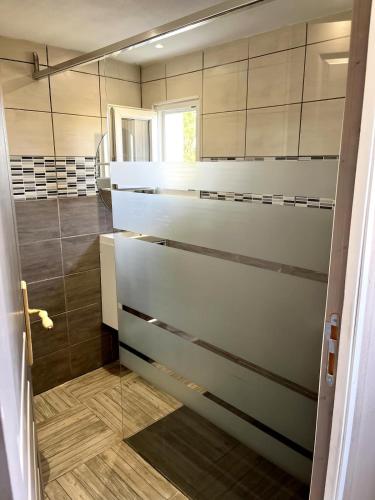 d'une cuisine avec des placards blancs et une porte en verre. dans l'établissement La sérénité en baie de somme, à Béhen