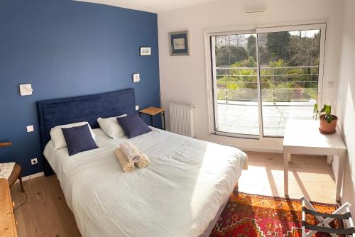 a bedroom with a large bed with a blue wall at appartement Terrasse KER HEOL - Proche centre Vannes in Vannes
