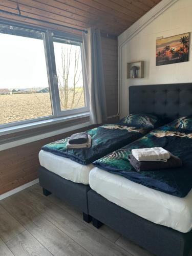 a bedroom with two twin beds and a window at ‘T huisje in Goeree in Goedereede