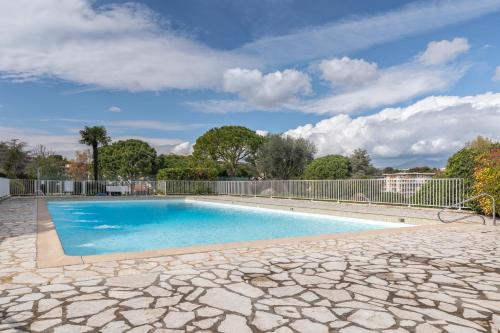 une piscine dans une cour clôturée dans l'établissement Le soleil d'or , Piscine et Tennis, à Antibes