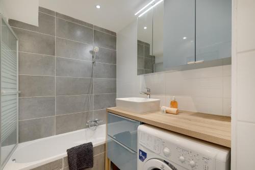 une salle de bain avec un lavabo et une machine à laver dans l'établissement Le soleil d'or , Piscine et Tennis, à Antibes