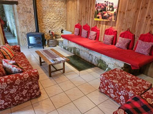 a living room with red couches and a fireplace at MOULIN DE L'HOSTE in Larzac