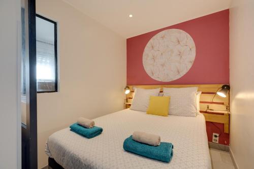 - une chambre avec un lit et des serviettes bleues dans l'établissement Le soleil d'or , Piscine et Tennis, à Antibes