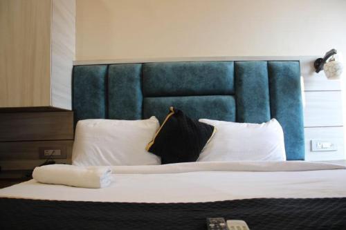 a bedroom with a large bed with a blue headboard at BLACKWOOD -140 Metres- Near Golden Temple in Amritsar