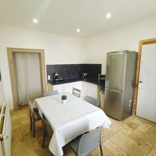 Il comprend une cuisine équipée d'une table blanche et d'un réfrigérateur. dans l'établissement ORB - Jardin proche gare, Luxembourg-Metz, à Uckange
