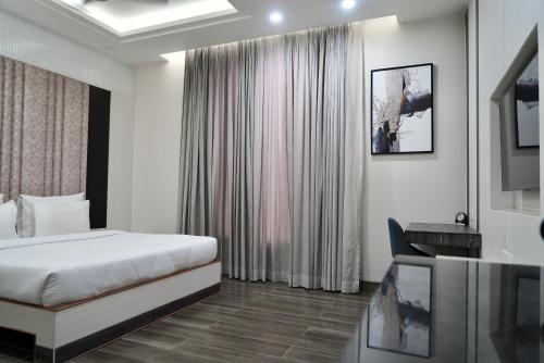 a hotel room with a bed and a desk at Hotel Elinor By Dazzling Hotels & Resorts in Agra
