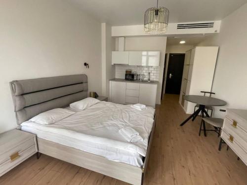 a bedroom with a bed and a table in it at Luxury Suites White Sails in Batumi