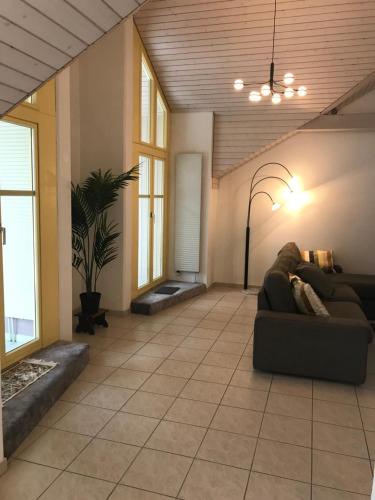 a living room with a couch on a tile floor at Beautiful apartment in the center of Switzerland in Erstfeld